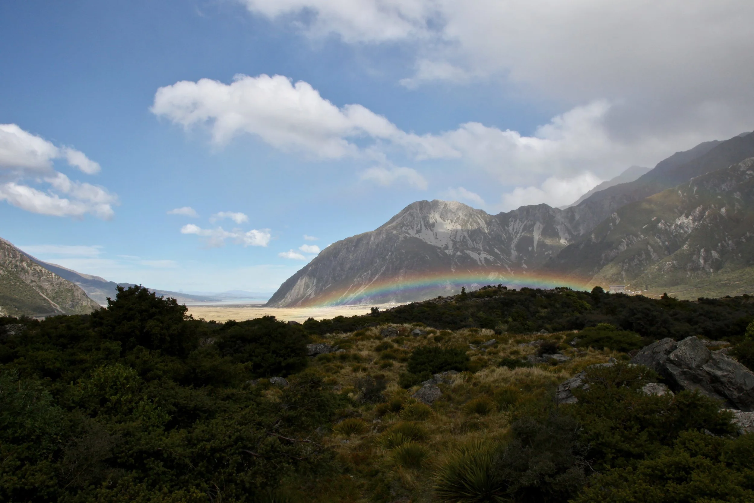 A blue sky and rainbow over Mt Cook village. Turn it up, NZ!