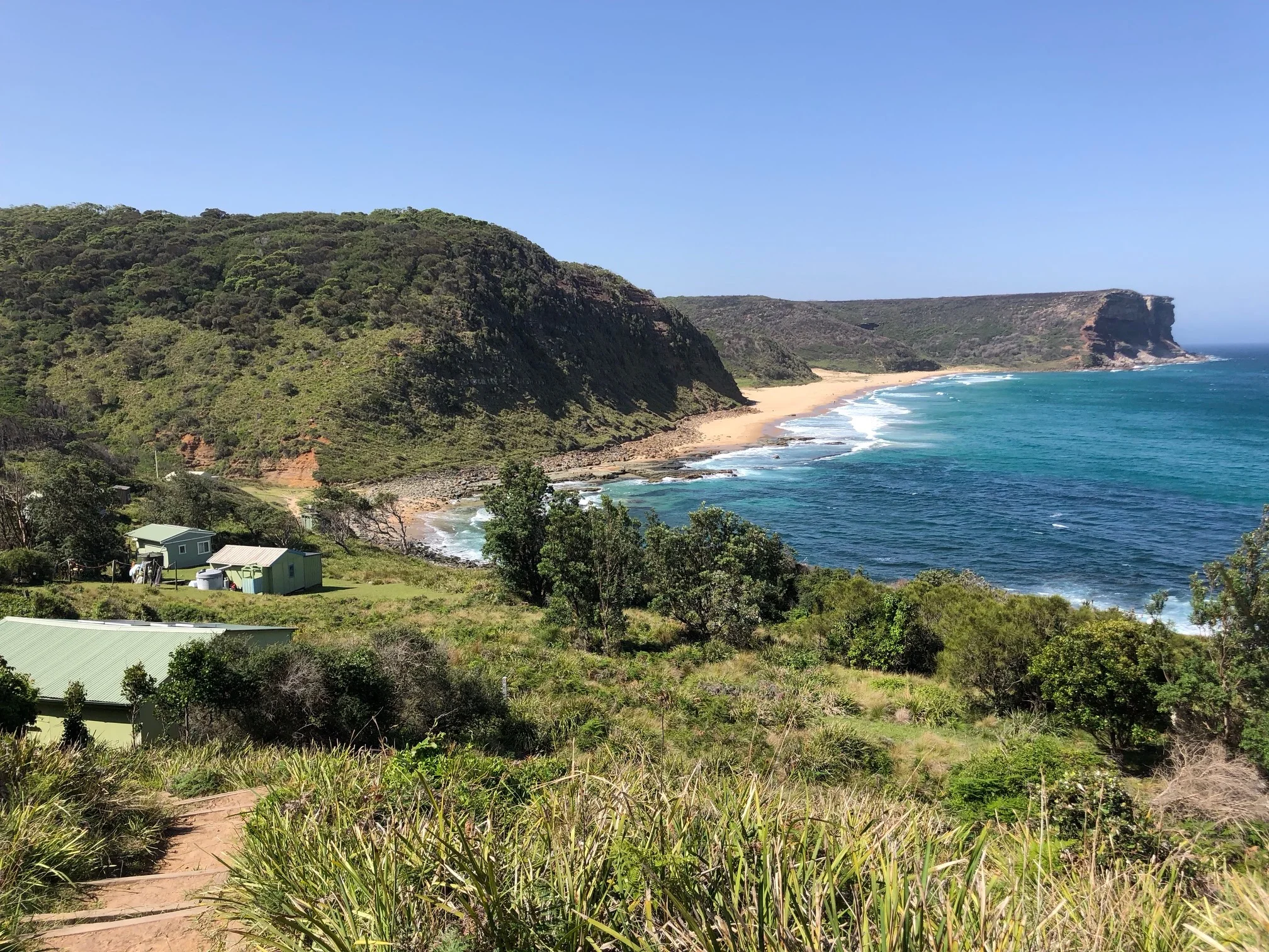 View over Garie Beach and some of the coastal shacks.