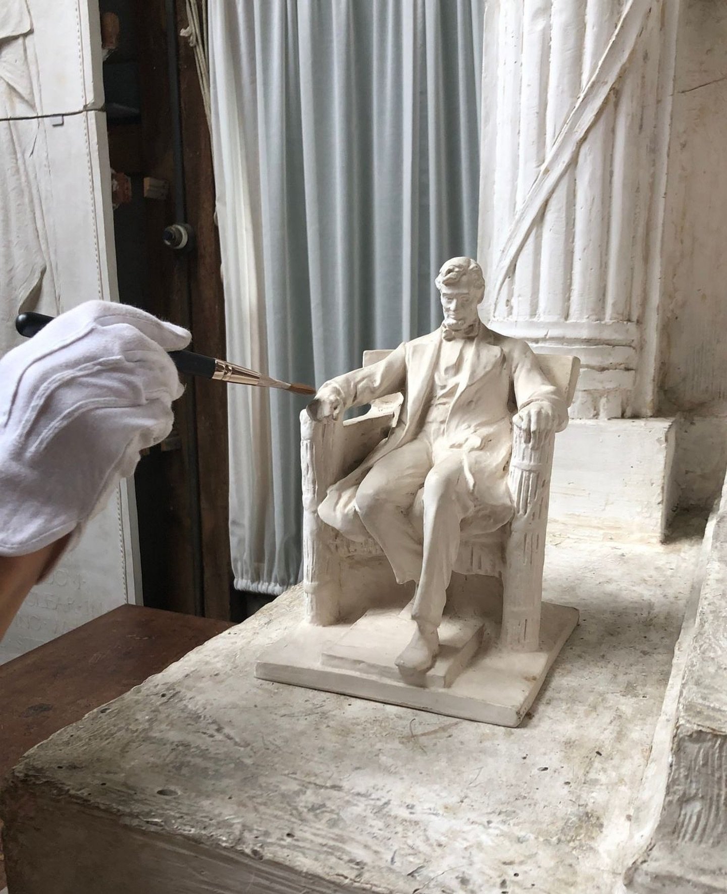 Anyone else finding it time for spring cleaning? 🧹 

#behindthescenes 
. . . 
Image: a gloved hand gently dusts the maquette of for the seated Lincoln of the Lincoln Memorial at the Chesterwood Studio.