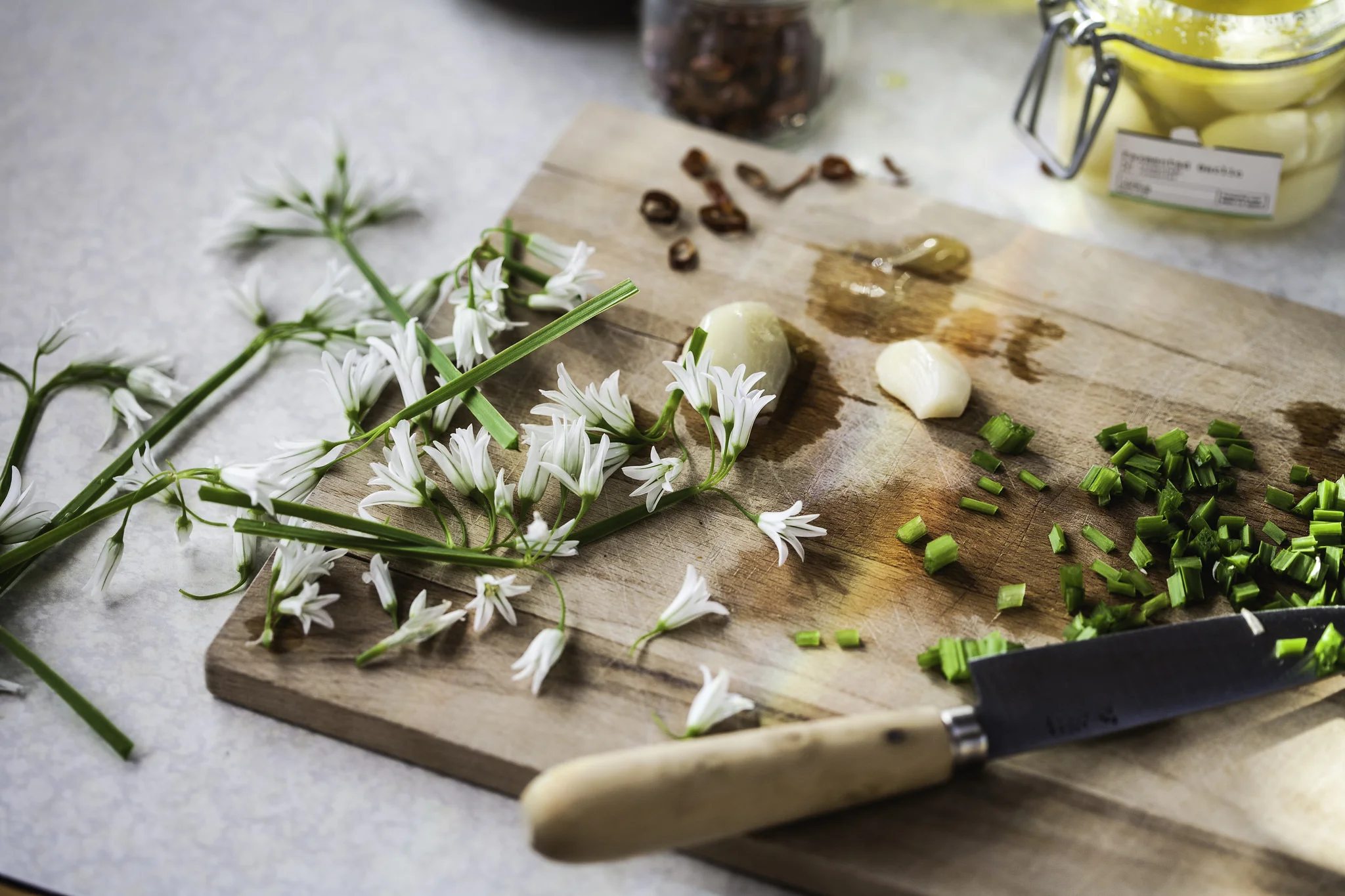 Chopping foraged wild angled onion (wild garlic), fermented garlic and dried chili with a paring knife.