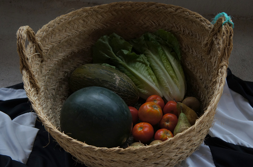 The July harvest of the Ricote Valley, hand made reed baskets made in the Ricote Valley, laid atop an elongated Almohad flag sewn by Moroccan dressmaker Saadia El Ankaoui.