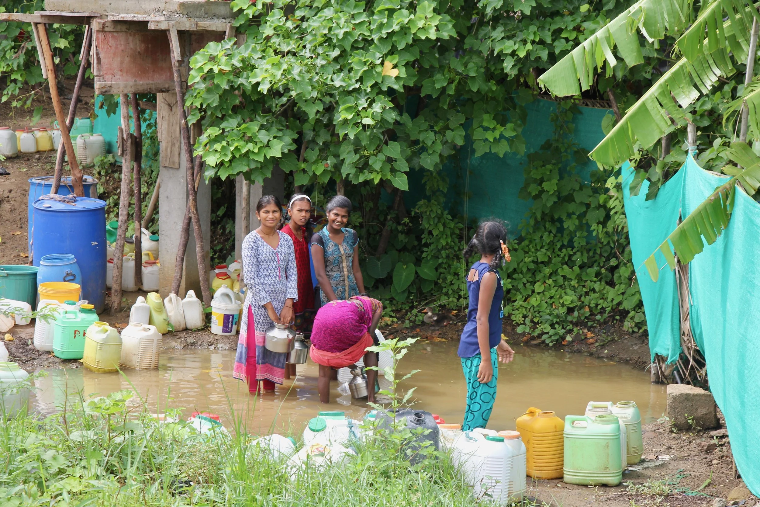 Young girls collect water for their families from a pond that fills up with water after the rain hits the village. This water is usually not clean, yet people walk to and from the pond to bring water back home, as there are no other facilities nearby.