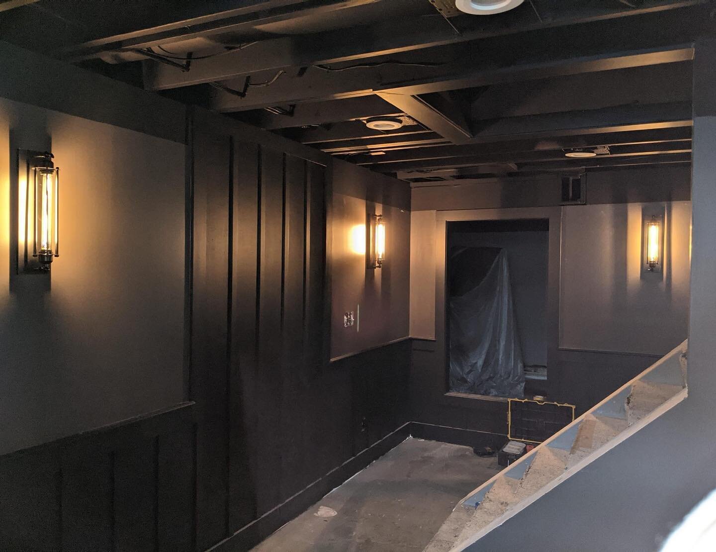 Black painted ceilings and dark colors are giving this basement a pub like feel.  Custom bar and exercise room are being built next.