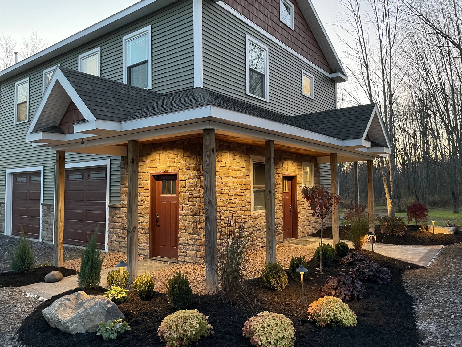 New home construction Syracuse with stone front porch, timber columns and landscaping