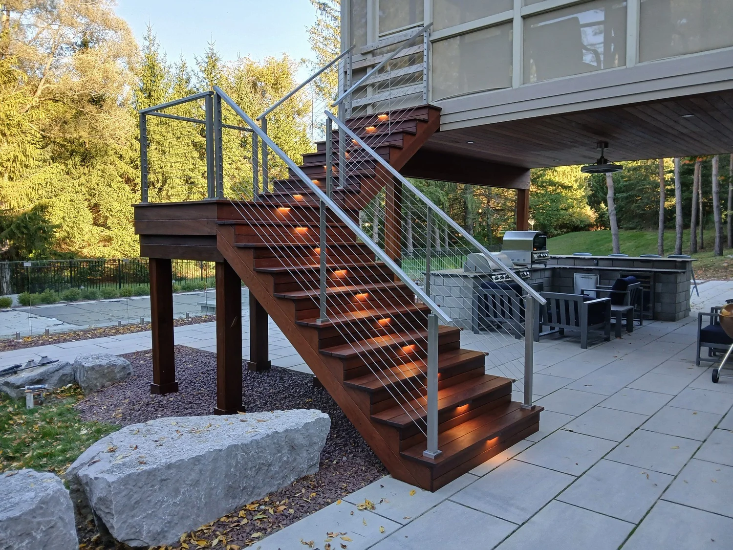 Composite deck installation Syracuse NY with wide stairs, cable railing and stair lights