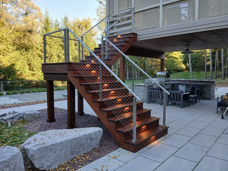 Deck builder Syracuse NY composite deck stairs with cable railing and stair lights