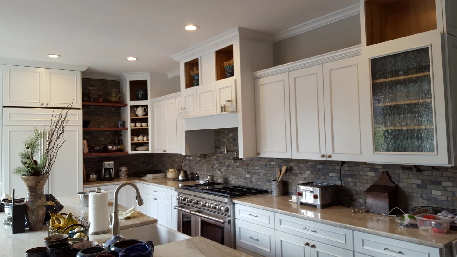 Kitchen remodeling Syracuse NY with white cabinets, stone backsplash and stainless range