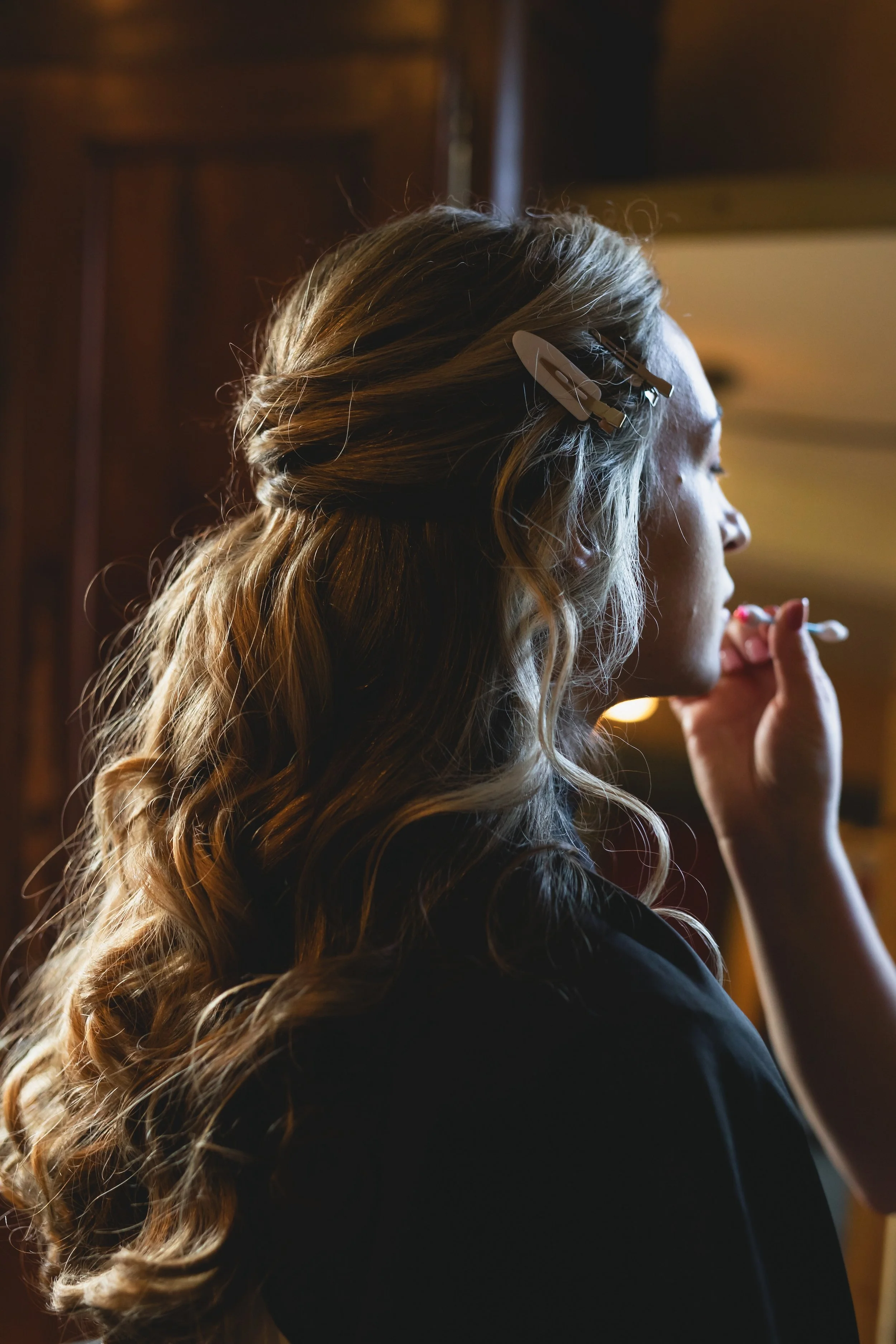 Bride with styled hair having makeup done while getting ready for wedding at FEAST at Round Hill