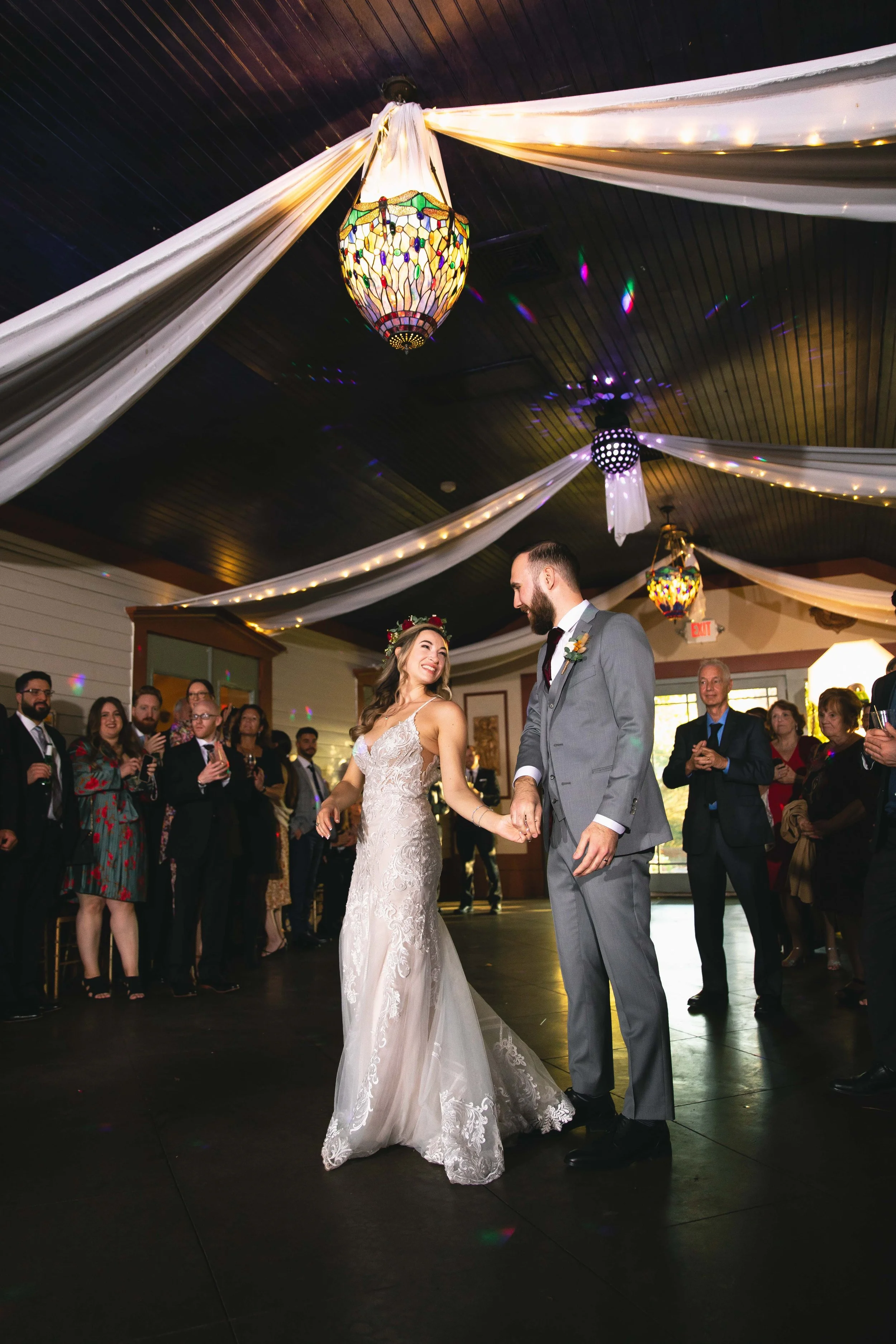 Groom spins bride during first dance in ballroom with wedding crowd at FEAST at Round Hill in Washingtonville, NY