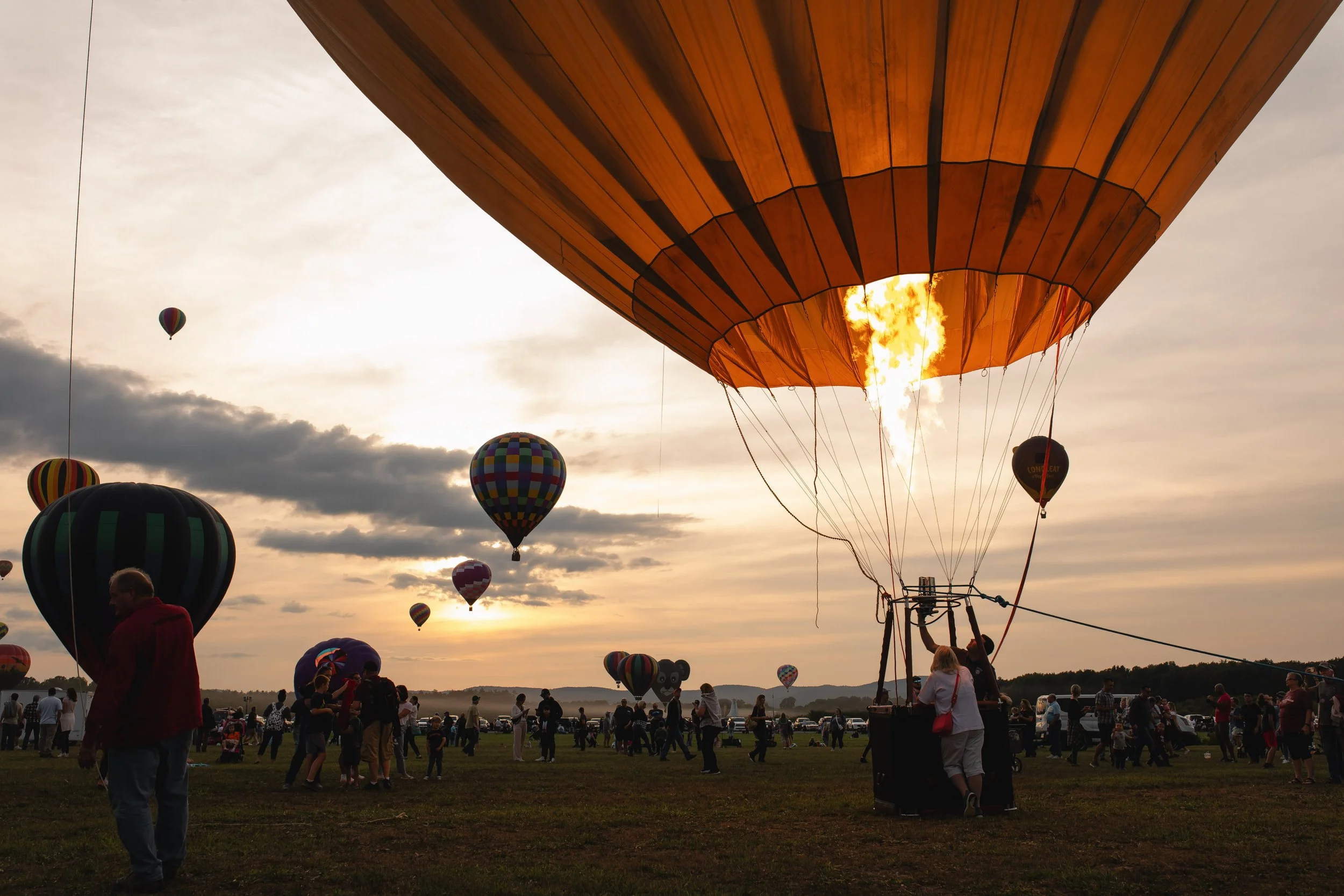 Lighting torch on hot air balloon during 2023 Adirondack Balloon Festival