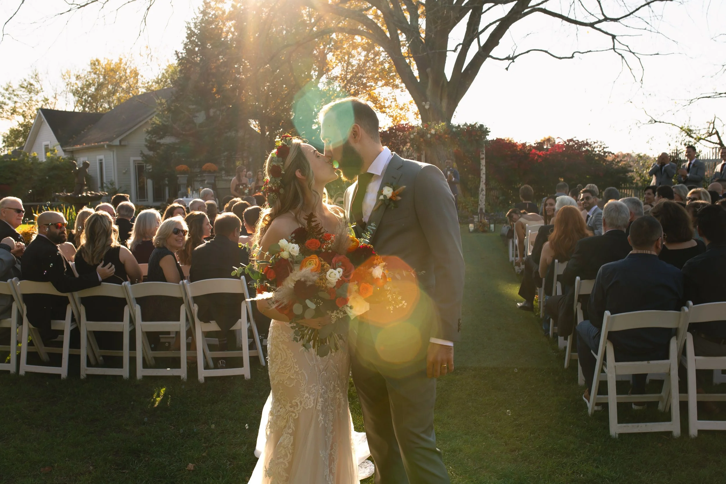 Bride and Groom kissing in sunlight after ceremony at FEAST at Round Hill Wedding Venue