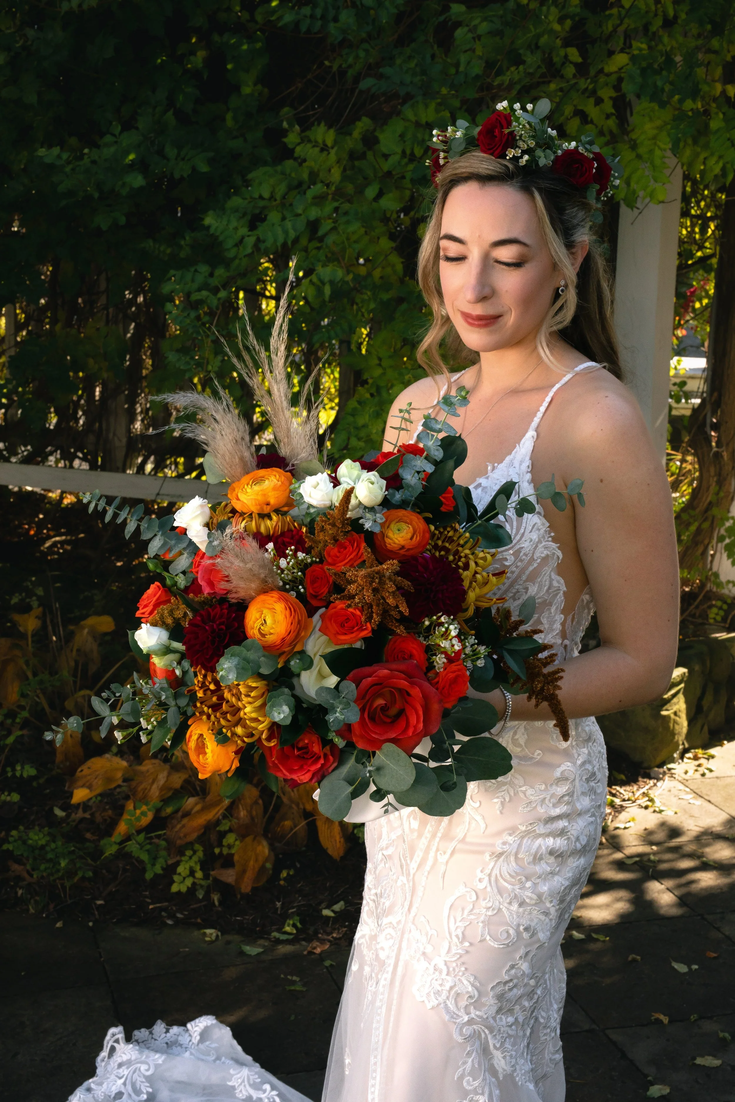 Bride holding fall wedding bouquet in outside garden at FEAST at Round Hill Wedding Venue in Upstate NY