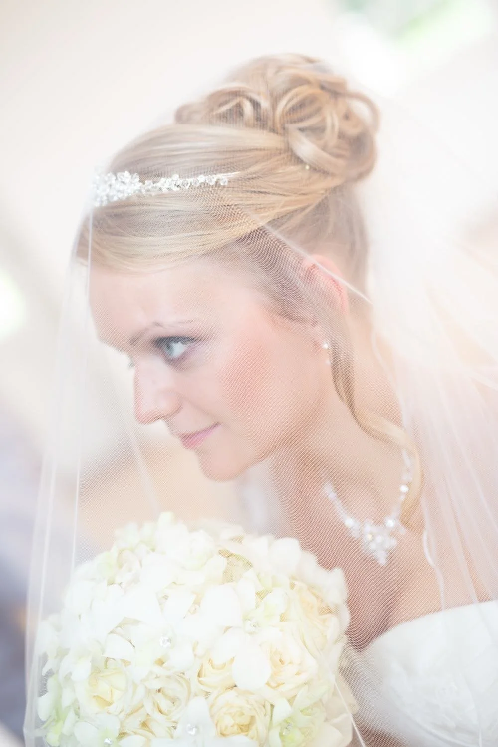 Braut mit hochgestecktem Haar, Schleier und Perlenhaarschmuck, mit einem weißen Brautstrauß in Darmstadt – von pixelfeder