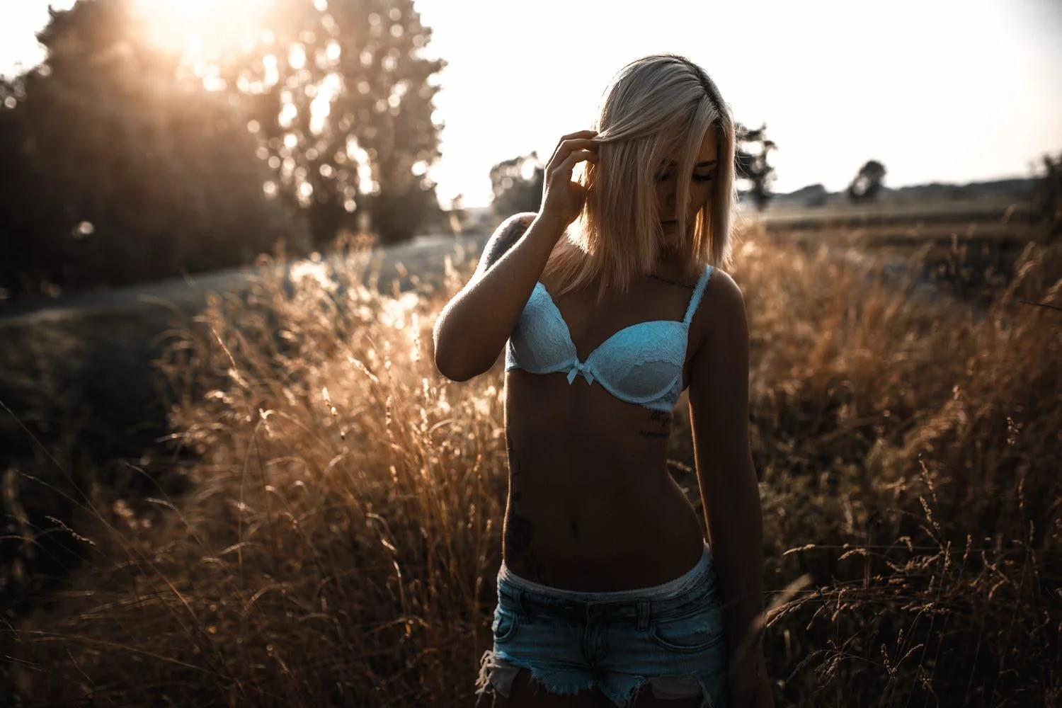 Portrait einer Frau in Jeans und in einem Weißen Top Outdoor bei Sonnenuntergang stehend in Frankfurt – von pixelfeder
