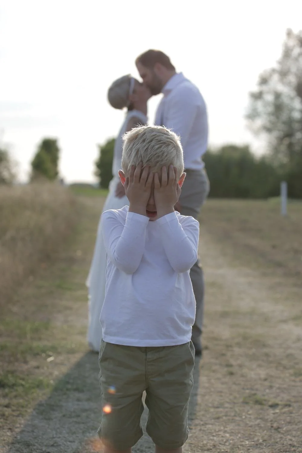 Ein Junge hält sich die augen zu wenn sich das brautpaar küsst in Darmstadt – von pixelfeder