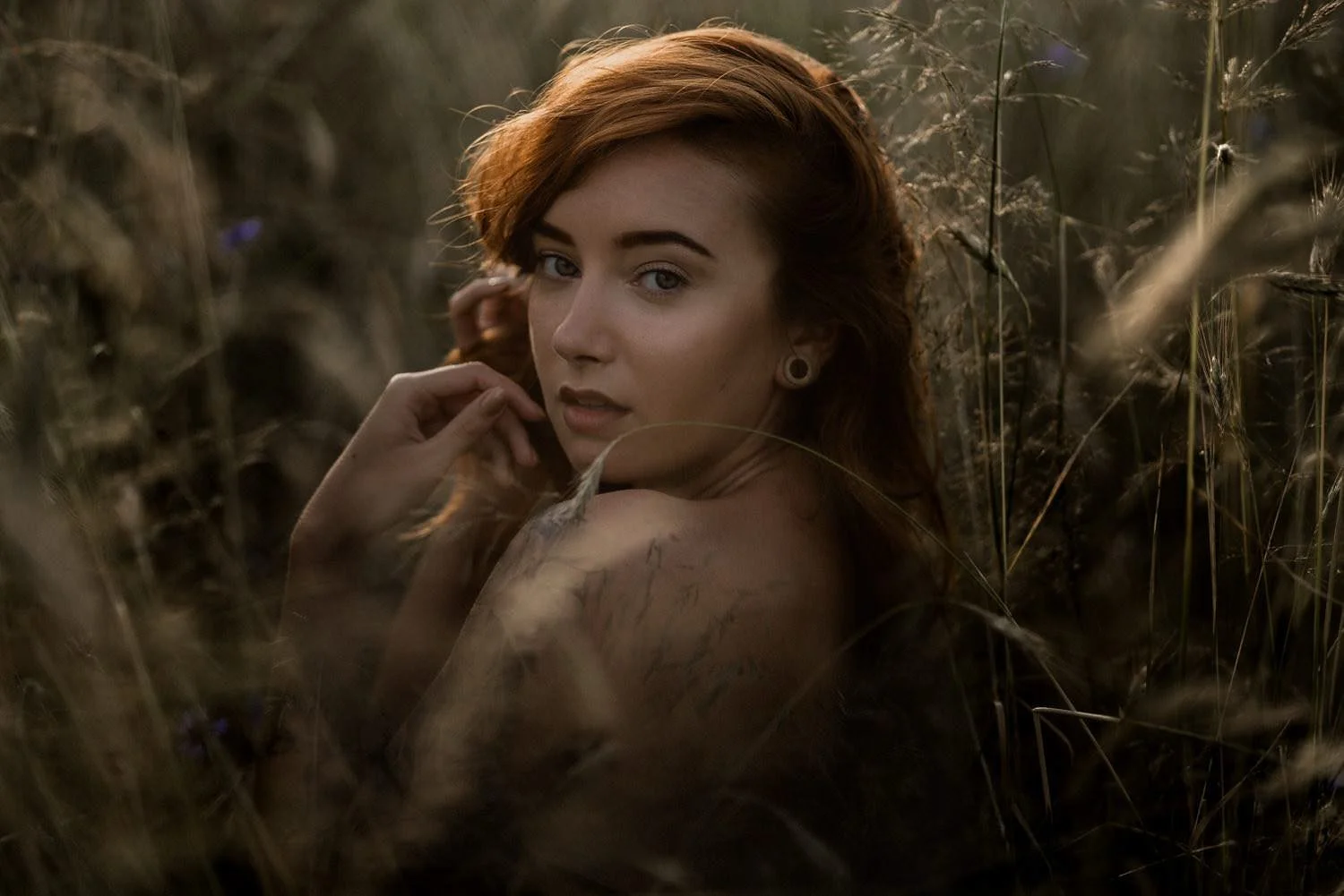 Portrait einer jungen Frau auf dem Boden sitzend mit Blick in die Kamera bei Sonnenlicht in Frankfurt – von pixelfeder