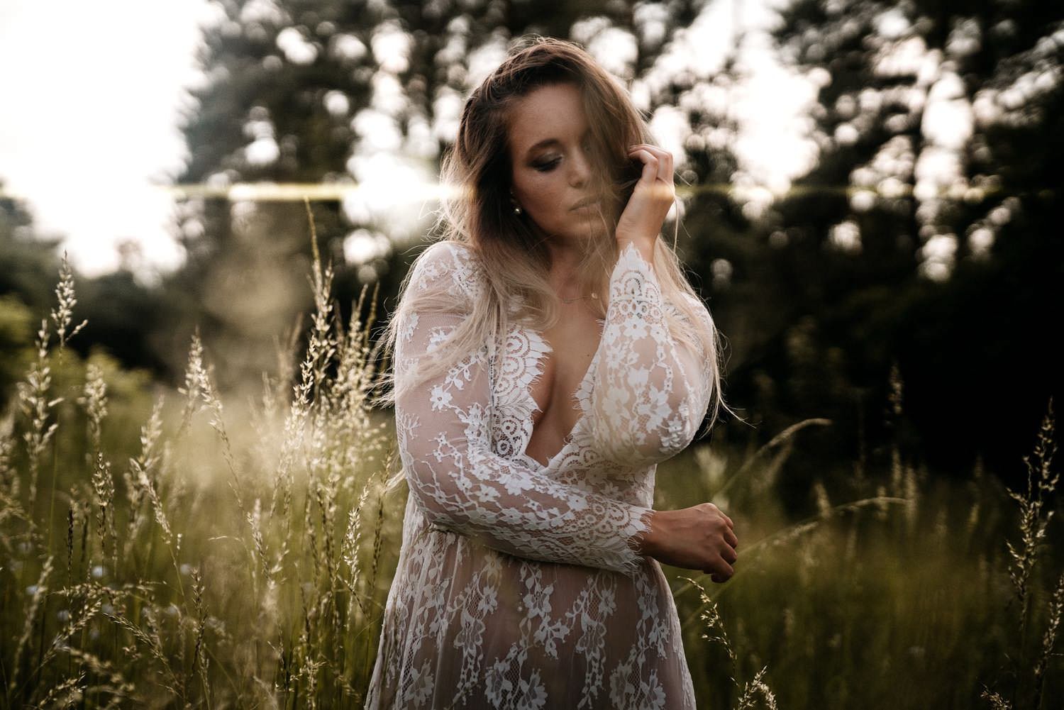 Sinnliches Portrait einer Frau in einem Spitzenkleid bei Sonnenuntergang im Feld – von pixelfeder