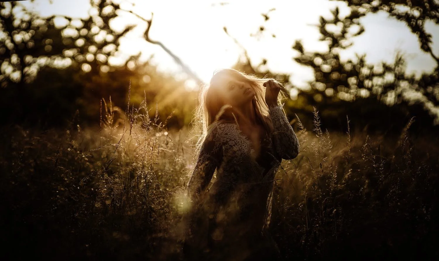 Portrait einer Frau bei Sonnenuntergang im Feld mit Blick in die Kamera – von pixelfeder