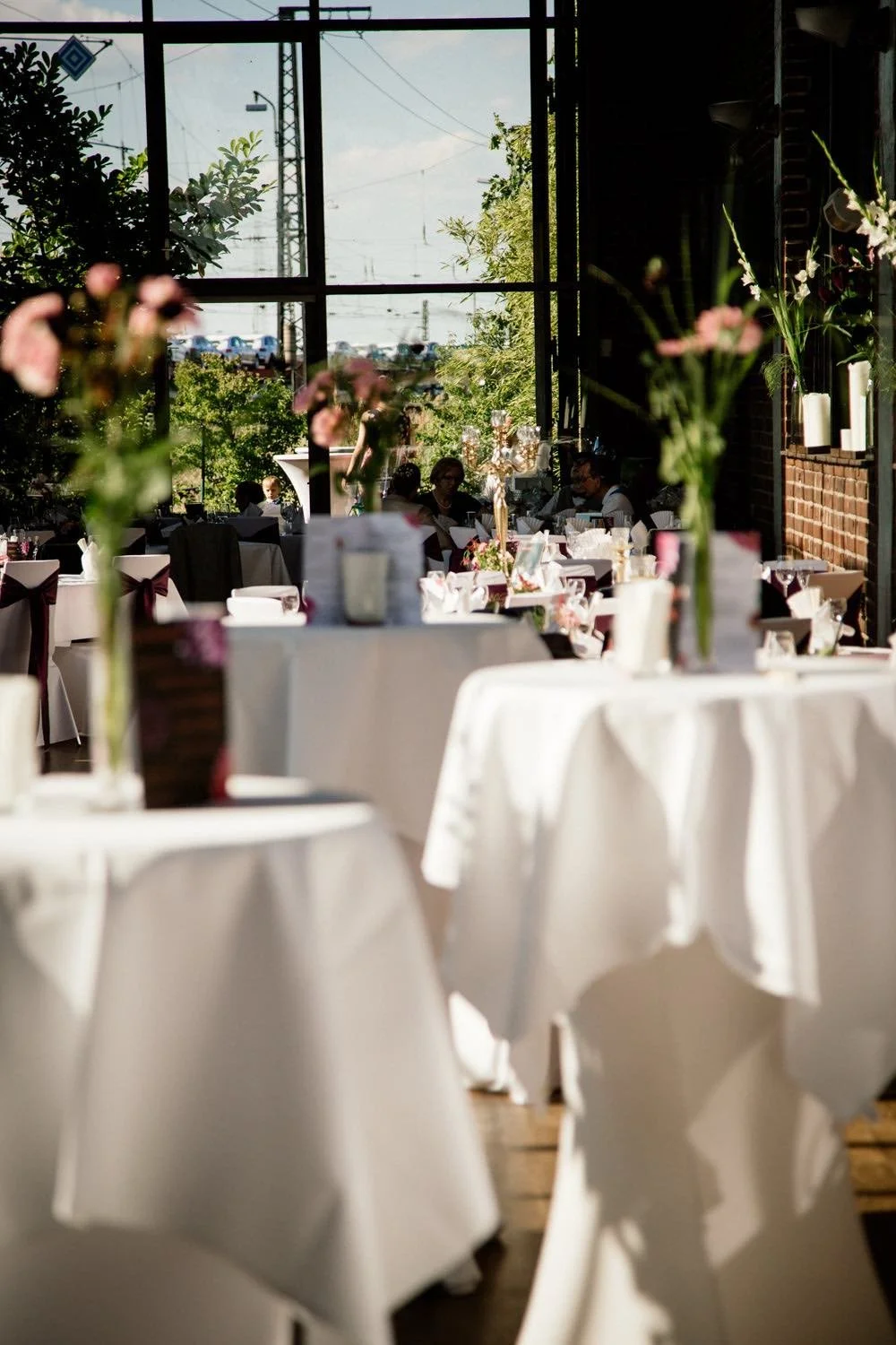 Eleganter, sonnendurchfluteter Veranstaltungsraum mit weißen Tischen in Darmstadt – von pixelfeder