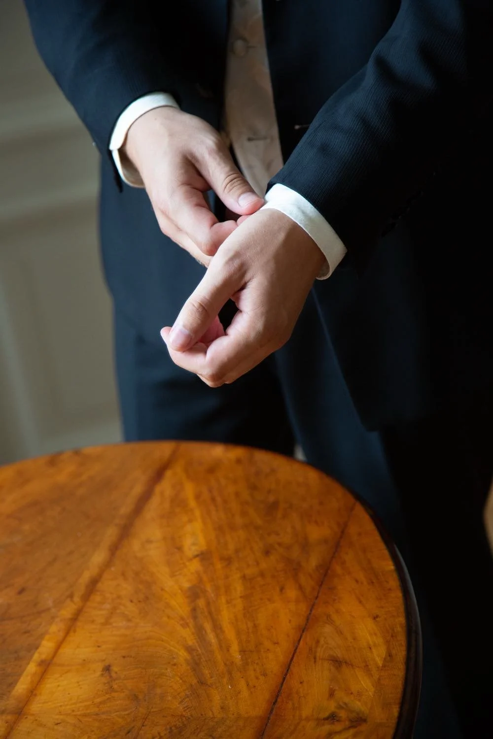 Close-Up des Bräutigams mit Weste und mit Manschettenknöpfen mit Holzdeko auf Holz in Darmstadt – von pixelfeder