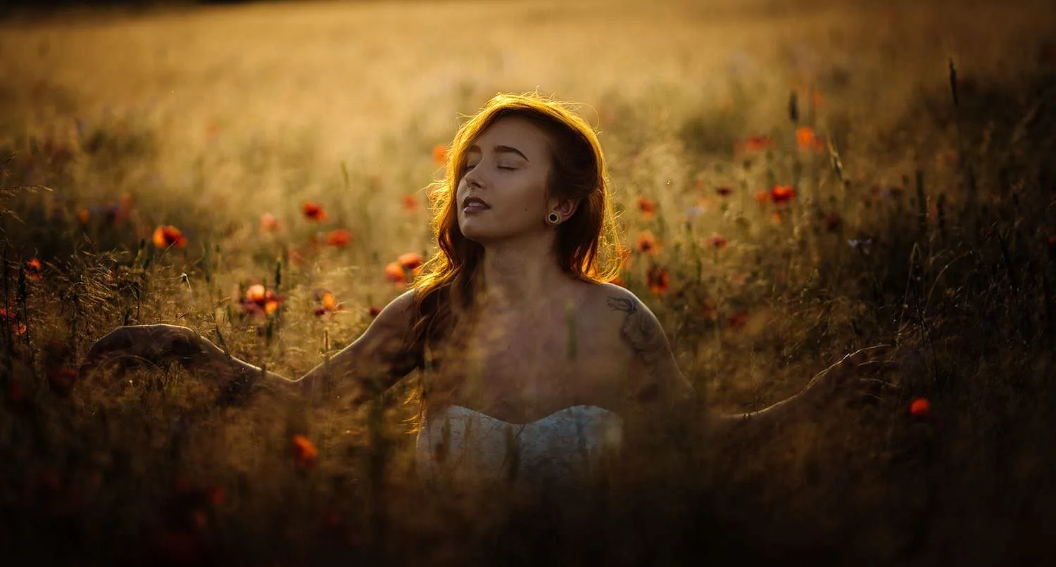 Portrait einer Frau Outdoor bei Sonnenuntergang auf dem Boden sitzend im mohnblumenfeld in darmstadt – von pixelfeder