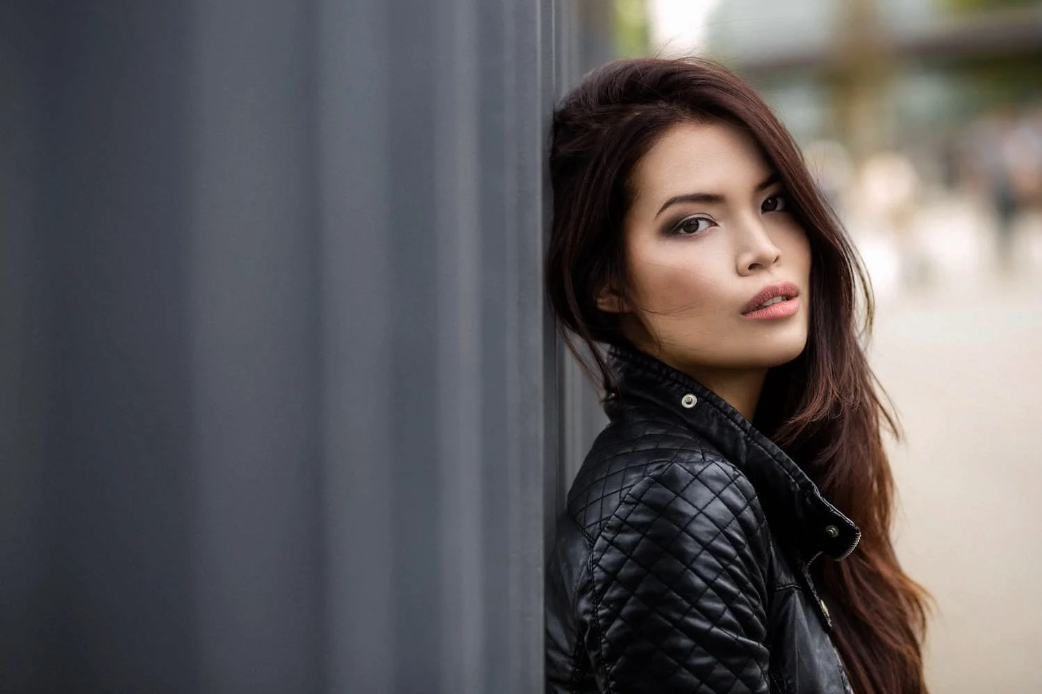 Portrait einer Frau mit langemen Haaren in einer Lederjacke in der City mit Blick zur Seite in Darmstadt – von pixelfeder
