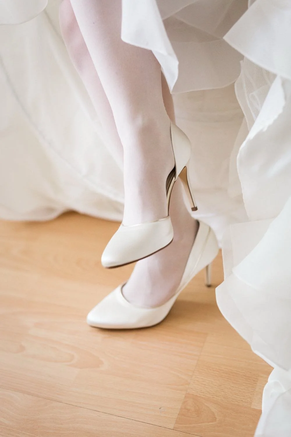 Getting Ready der Braut im Brautkleid und mit High Heels im Hotelzimmer in Darmstadt – von pixelfeder