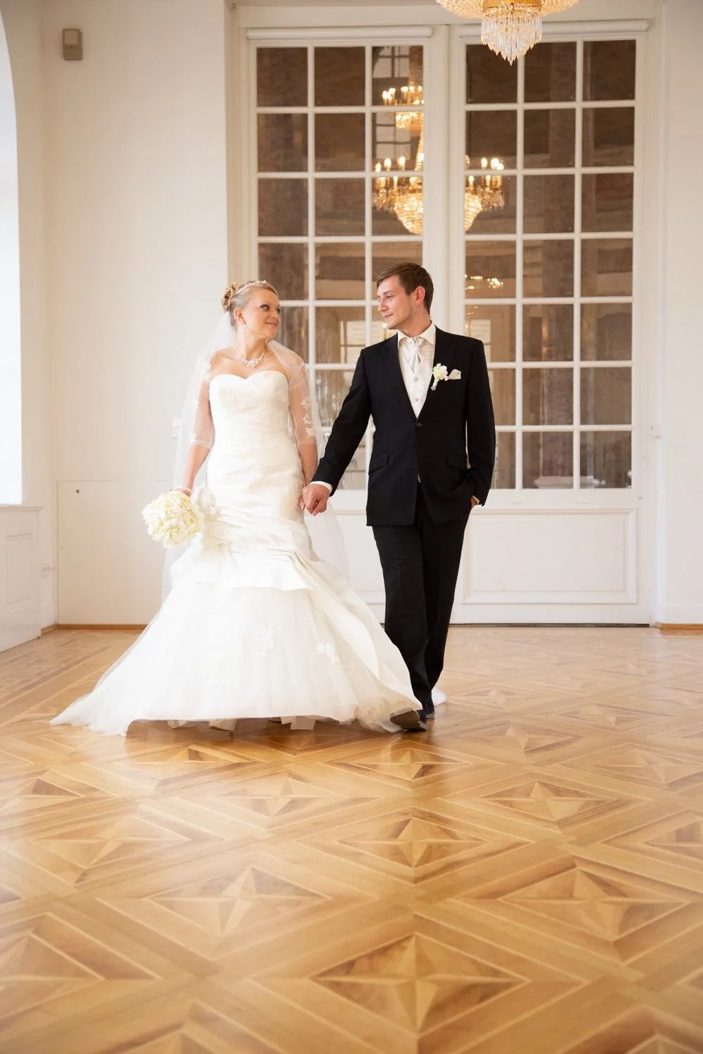 Ein Brautpaar tanzt im eleganten Raum mit Holzboden und Kronleuchtern in Darmstadt – von pixelfeder