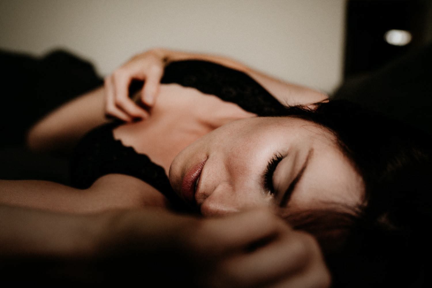 Sinnliches Portrait einer Frau mit braunen Haaren in einem Spitzenbody beim Homeshooting liegend – von pixelfeder