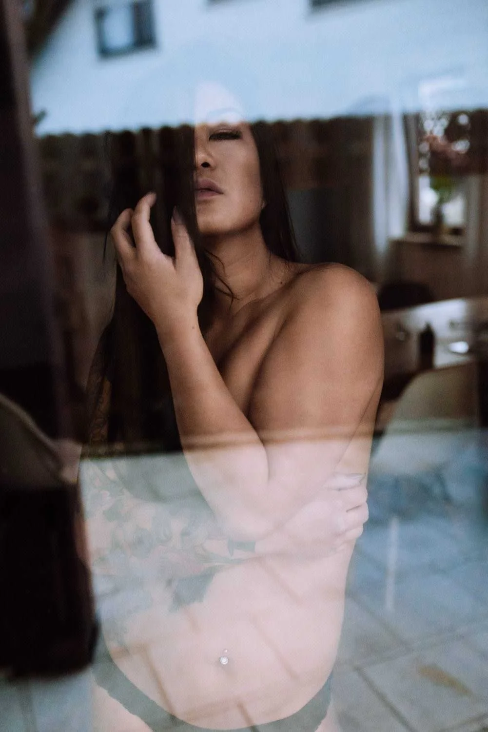 Portrait einer Frau mit langen, schwarzen Haaren in Dessous Indoor vor dem fenster in in Frankfurt – von pixelfeder