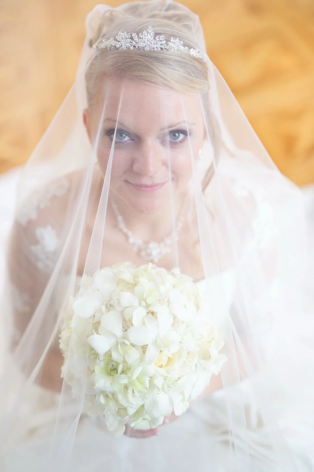 Braut mit Hochzeitskleid, kniet und hält einen weißen Blumenstrauß in Darmstadt – von pixelfeder