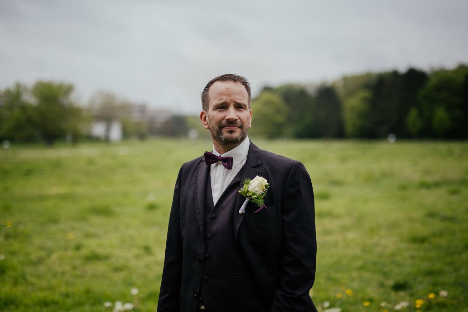 Portrait des Bräutigams im Anzug und mit Fliege und im Dunklem anzug im Garten in Darmstadt – von pixelfeder