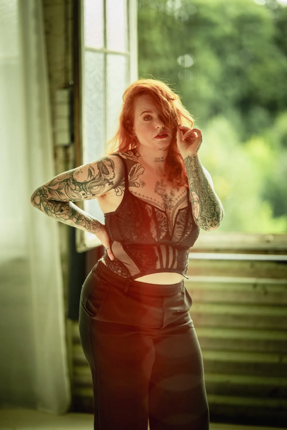 Portrait einer Frau mit offenen, roten Haaren im Studio mit Tattoos – von pixelfeder