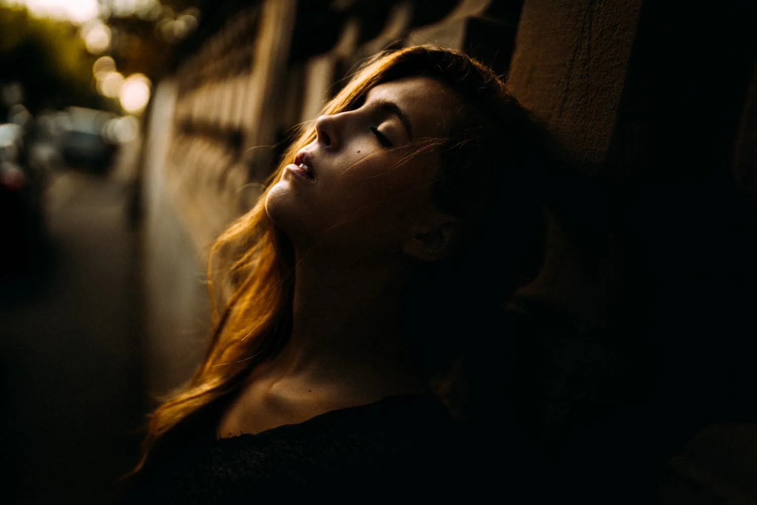 Portrait einer jungen Frau in der City mit geschlossenen Augen bei Sonnenlicht in Darmstadt – von pixelfeder