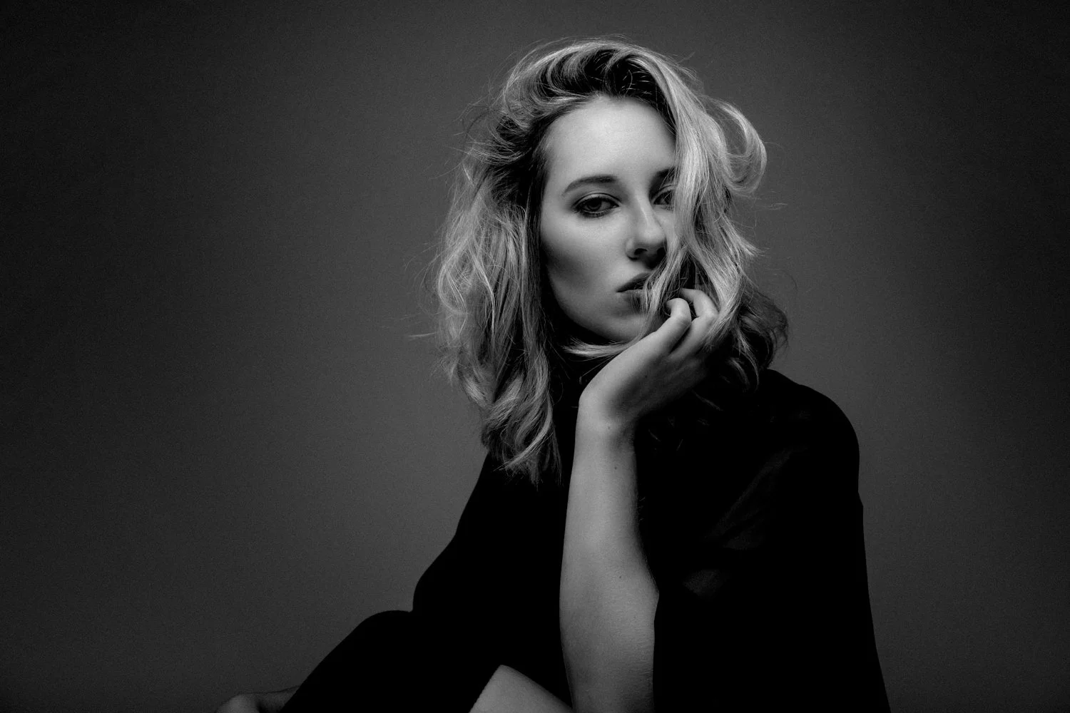 Portrait einer jungen Frau mit mittellangen, lockigen, blonden Haaren in Darmstadt – Schwarz-Weiß von pixelfeder