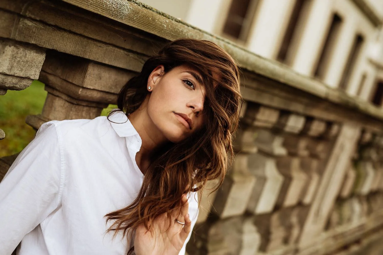 Portrait einer jungen Frau in einem Weißem Hemd Outdoor vor einer Wand auf dem Boden sitzend in Darmstadt – von pixelfeder