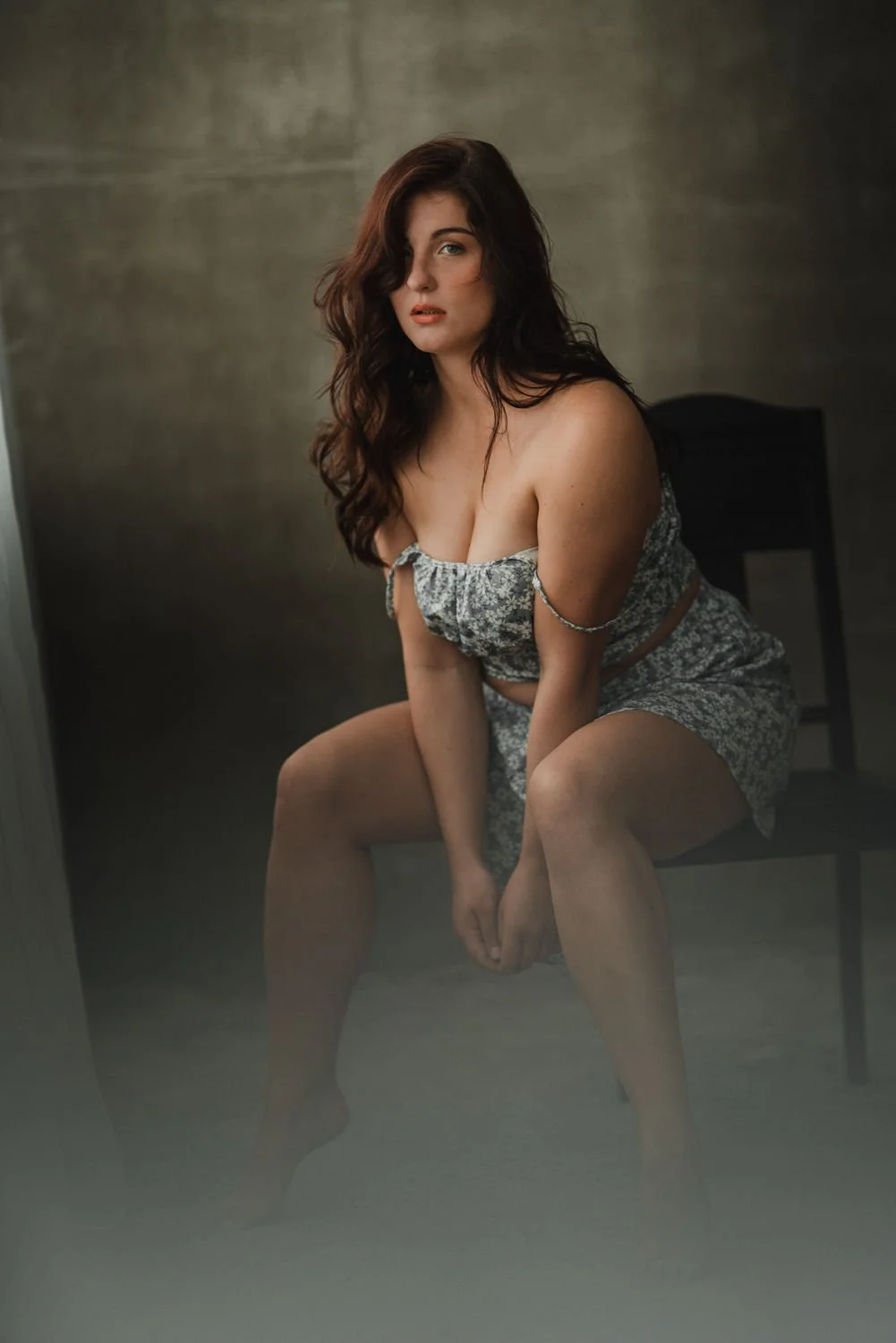 Portrait einer jungen Frau mit lockigen, hellbraunen Haaren in einem Kleid vor einer Wand in Frankfurt – von pixelfeder