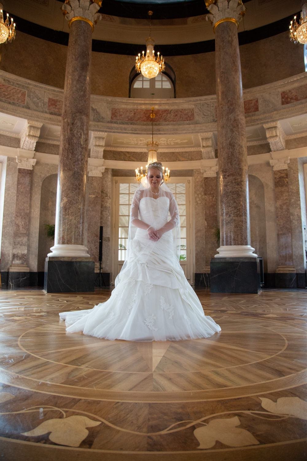 Braut in einem eleganten weißen Hochzeitskleid in einer prunkvollen Raum in Darmstadt – von pixelfeder