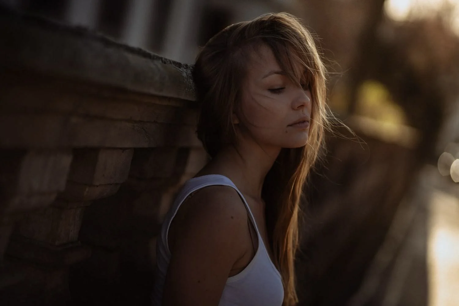 Portrait einer jungen Frau vor einer Wand bei Sonnenlicht mit verträumtem Blick in Darmstadt – von pixelfeder