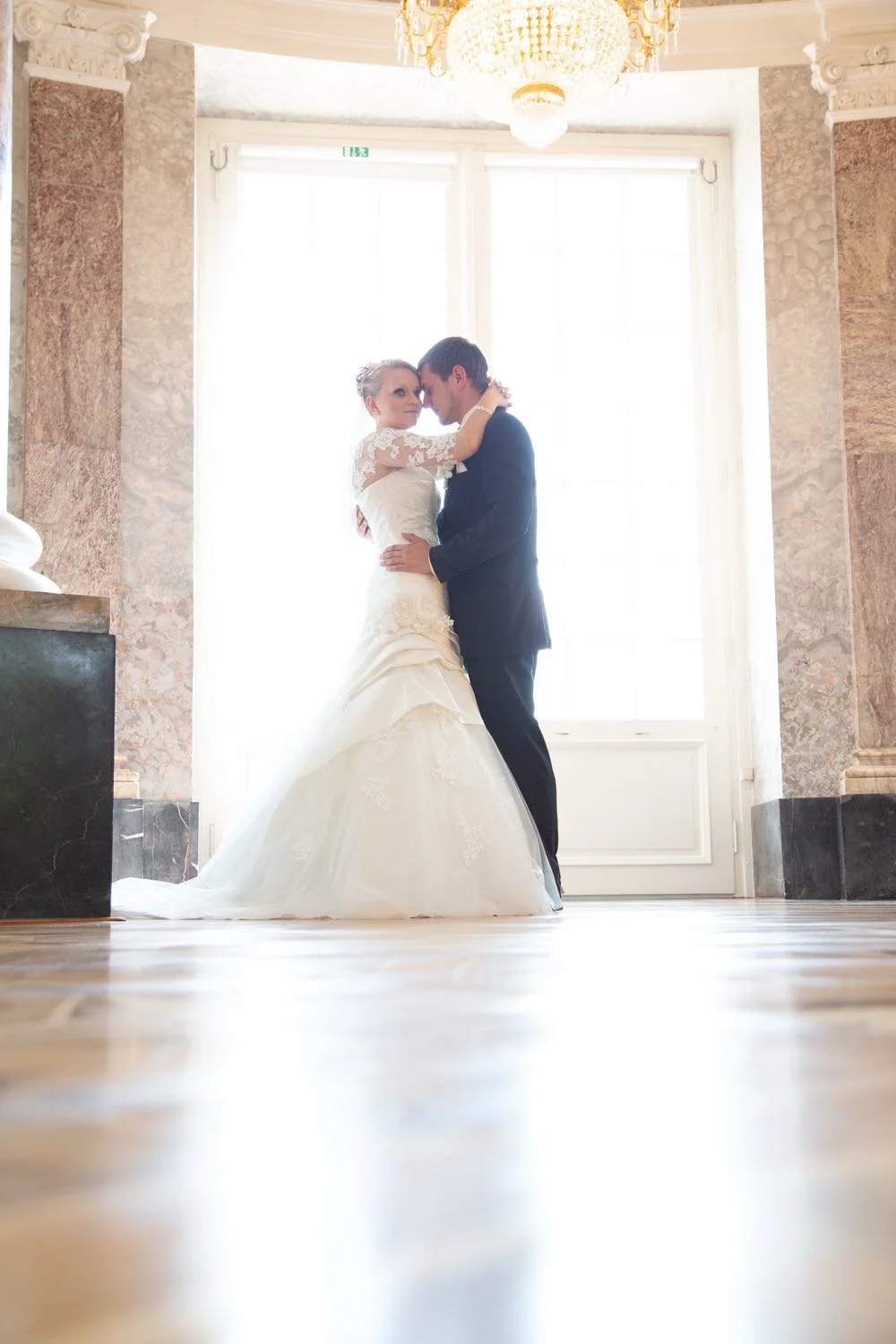 Ein Brautpaar steht sich in einem hell erleuchteten Raum mit großen Fenstern gegenüber in Darmstadt – von pixelfeder