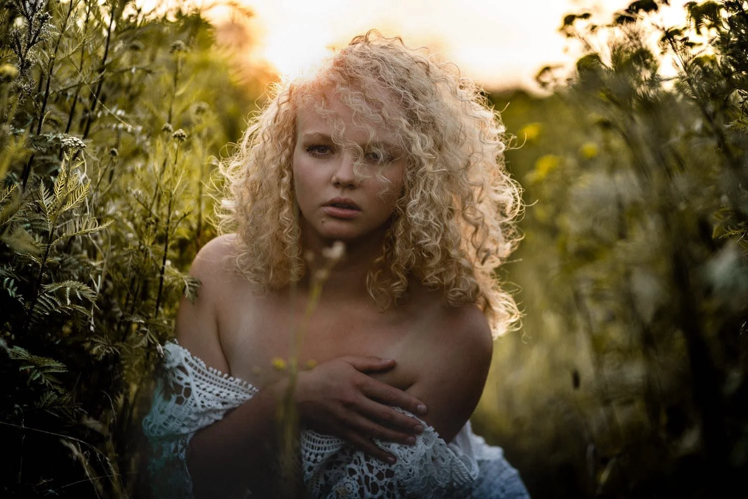Portrait einer Frau mit lockigen, blonden Haaren mit schulterfreiem Oberteil im Feld – von pixelfeder