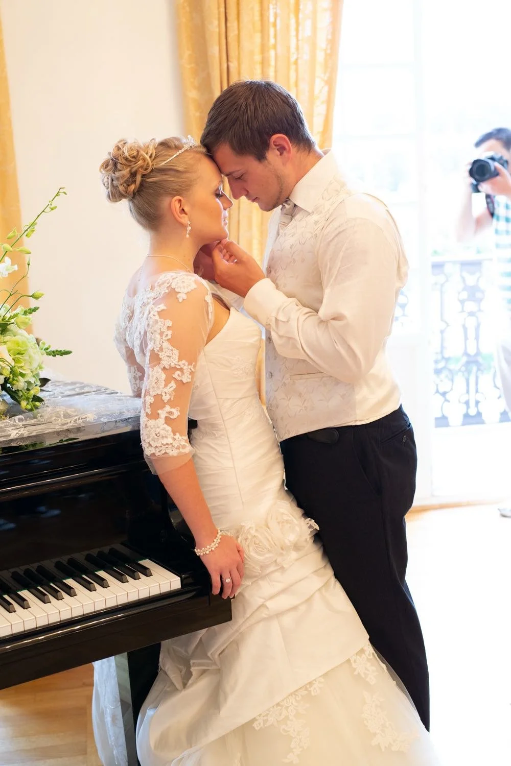 Ein Brautpaar während ihrer Hochzeit, das sich innig berührt und stehen am Klavier in Darmstadt – von pixelfeder