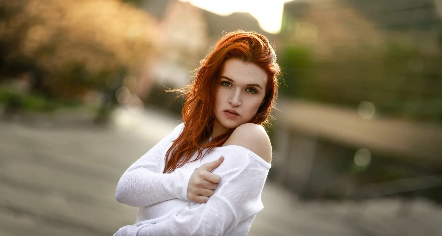 Portrait einer jungen Frau mit roten Haaren mit schulterfreiem Oberteil bei Sonnenuntergang in Darmstadt – von pixelfeder