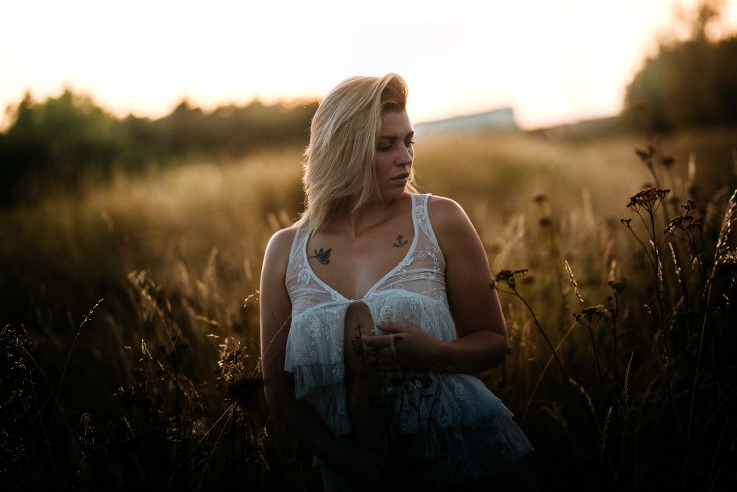 Portrait einer Frau in einem Kleid bei Sonnenuntergang mit Blick zur Seite mit Tattoos – von pixelfeder