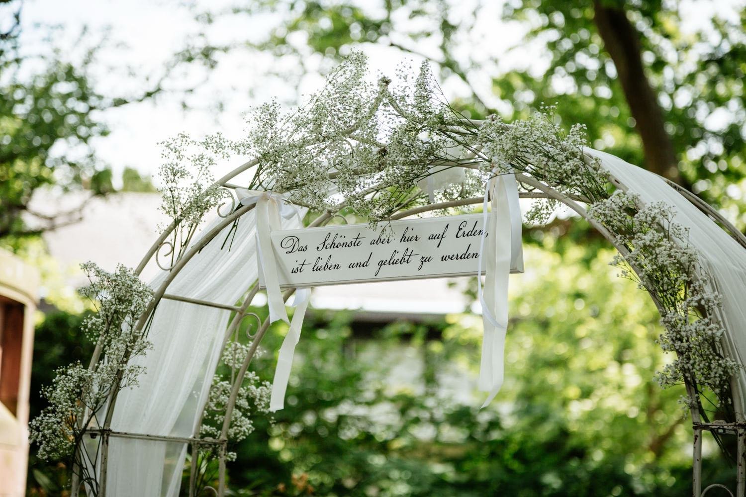 Ein weißer Blumenbogen mit weißen Tüllvorhängen, verziert mit kleinen weißen Blumen vor der hochzeit, in darmstadt - pixelfeder