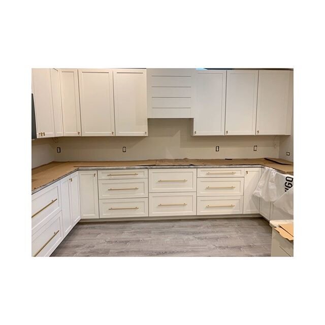 Simple white shaker cabinets with brass hardware.