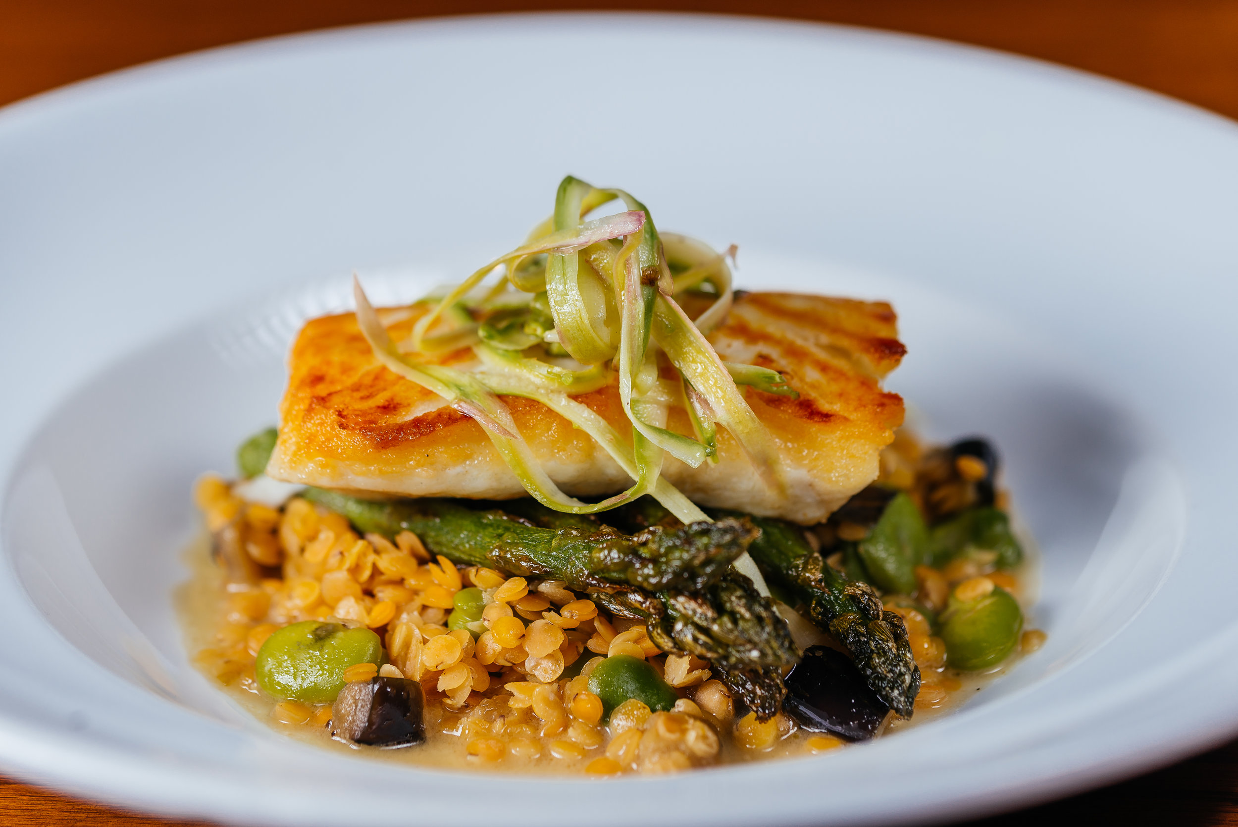 Pan roasted halibut with green curry farro, charred asparagus, and red lentils