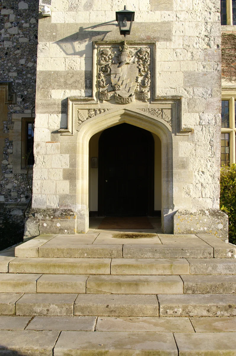 The front entrance of Chawton House, with the Knight family motto and heraldry carved in stone above the front door