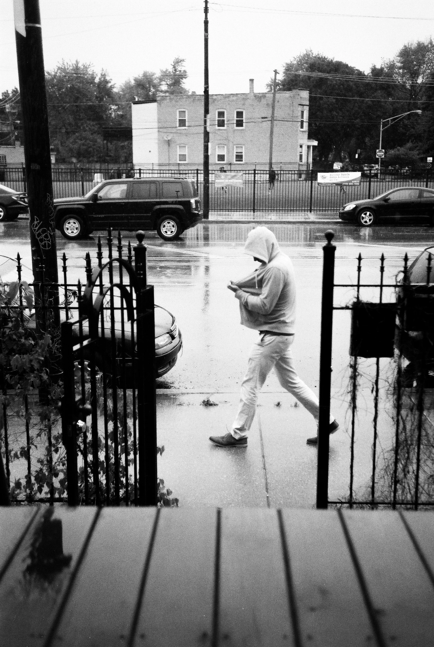 man walking past gate rainy film.jpg