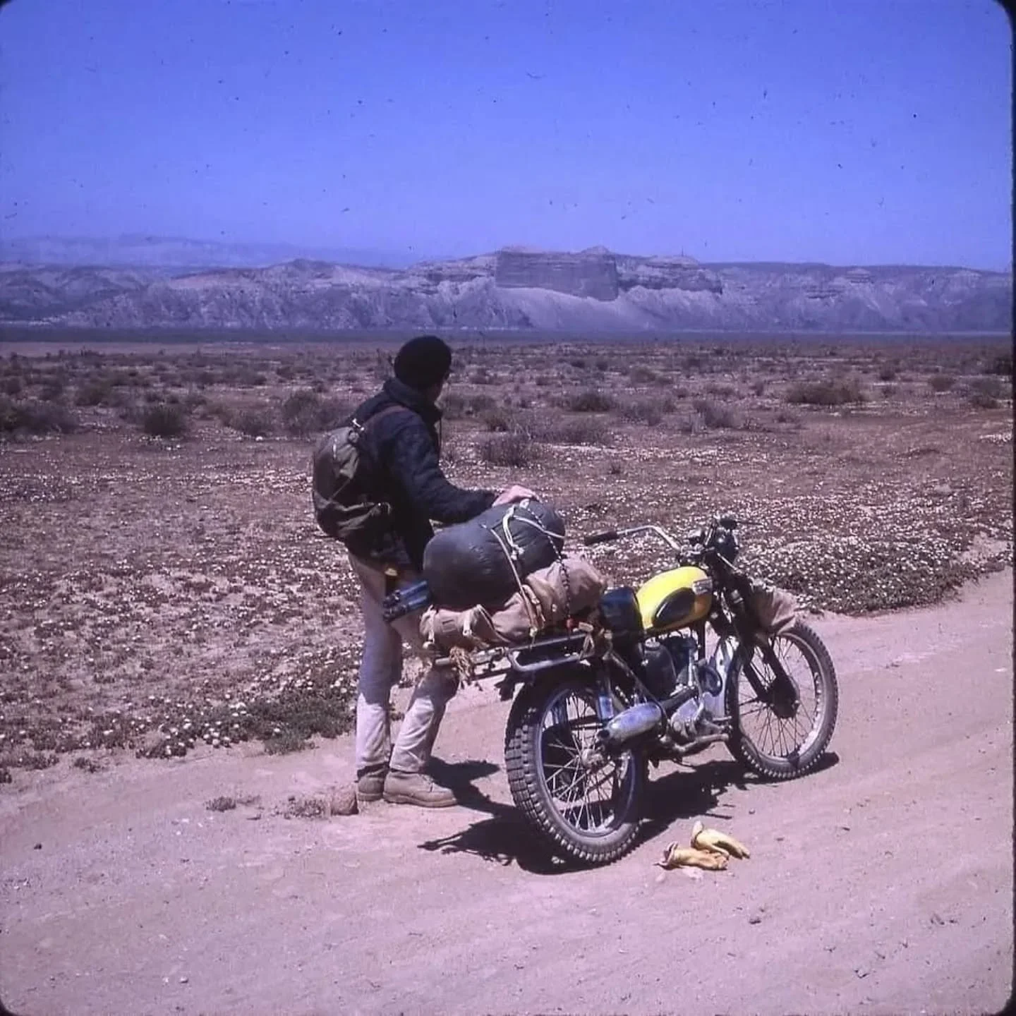 Bruce and his friend Del Cannon planned a trip from Encinitas, CA, to Baja aboard Triumph Mountain Cubs. A rookie packing job left them carrying 60lbs on their back, which caused Bruce to crash just three miles into the voyage. Other setbacks include